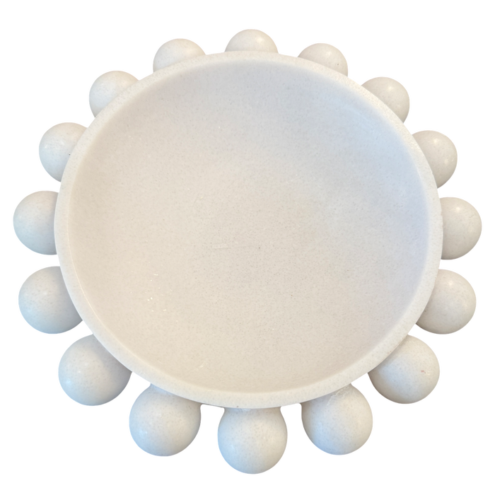 A white ceramic or stone round dish with a raised rim and multiple small rounded protrusions around the edge, shown on a plain white background.