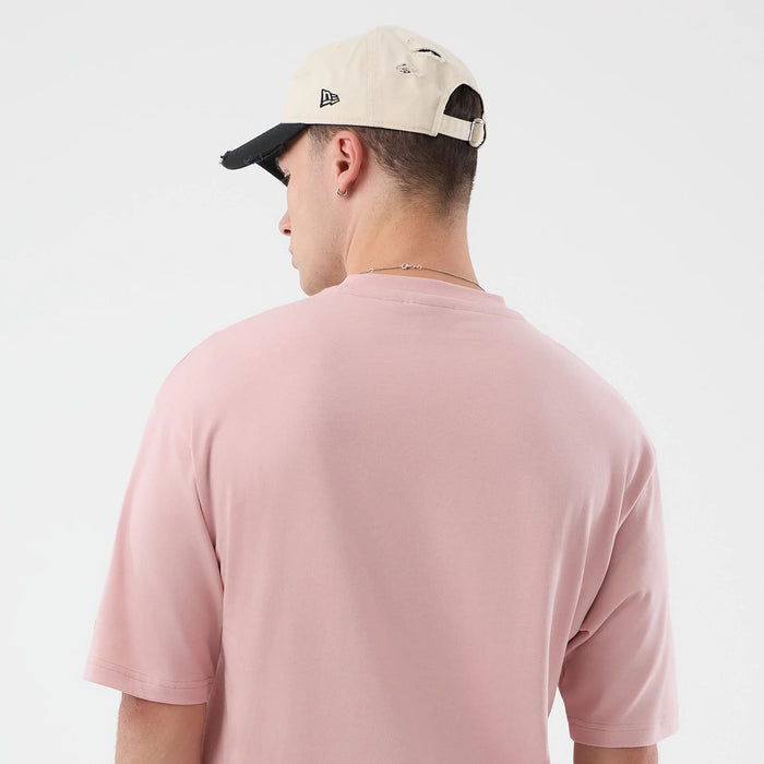 The model is wearing this New Era Beach Graphic Oversized T-Shirt in pastel pink. 8