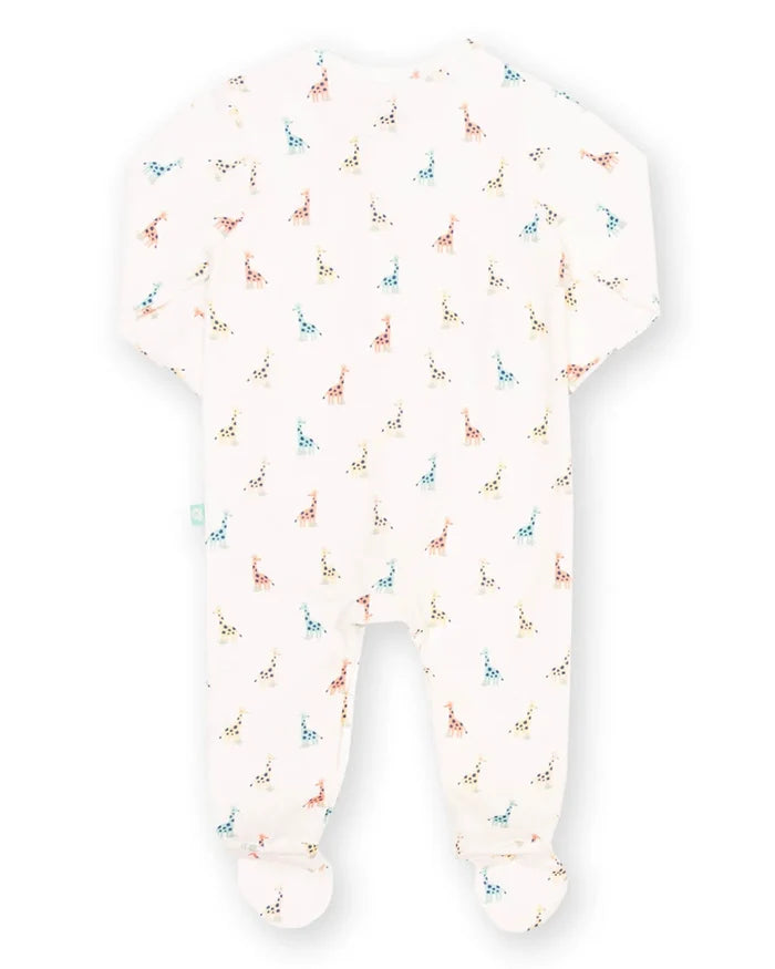 A baby footed sleeper in a warm off-white fabric, featuring a delicate all-over print of small colorful giraffes in blue, orange, and green.