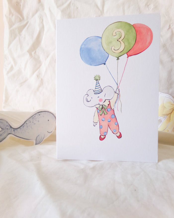 Children's birthday card with a cartoon elephant holding balloons and the number 3 on a white background.