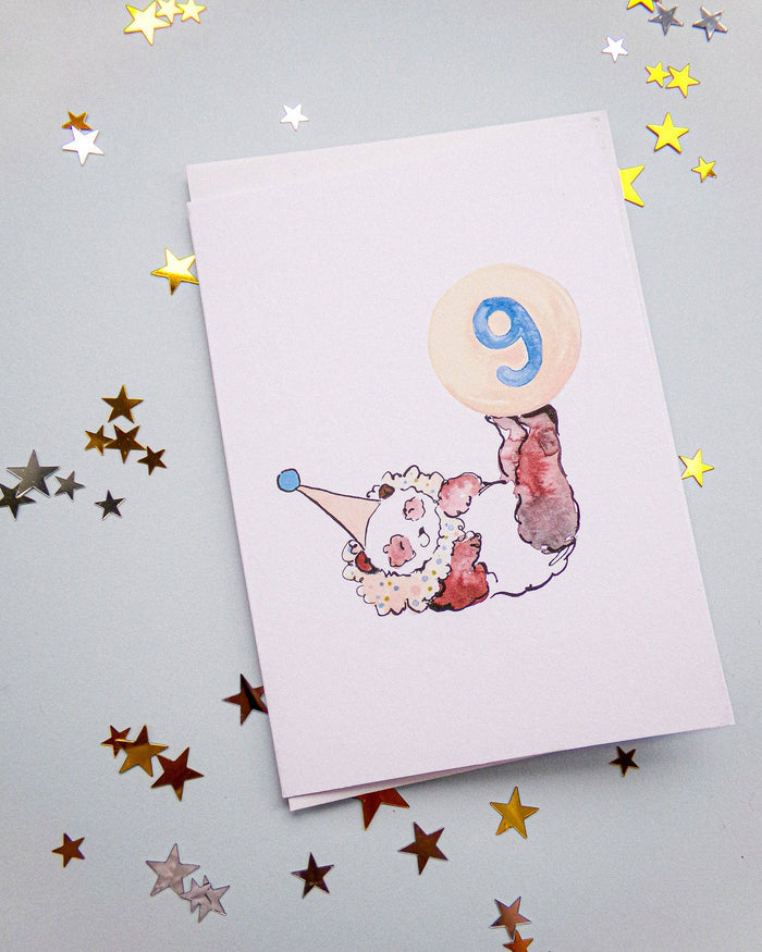Card with a clown design and number 9 on a gray background with star confetti