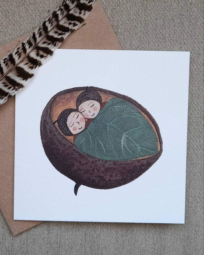 Card with illustration of two people in a shell, feather, and envelope on a textured surface