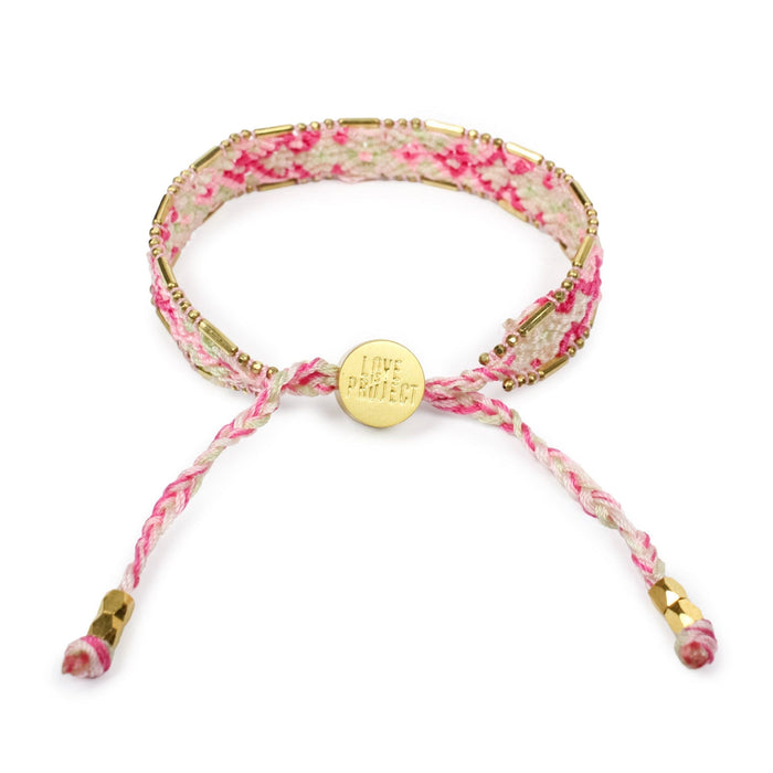 Floral patterned bracelet with a gold charm on a white background