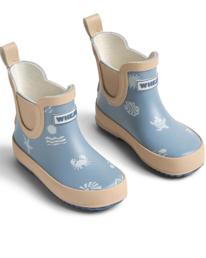 Pair of blue children's rain boots with beige accents on a white background