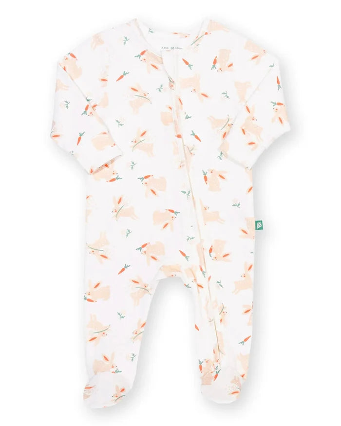 A baby footed sleeper in white with a light peach and orange bunny print, shown flat on a white background.