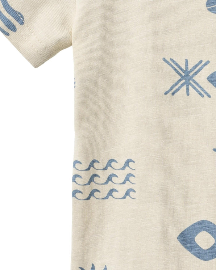 Beige fabric with blue geometric patterns including stars, waves, and shapes.