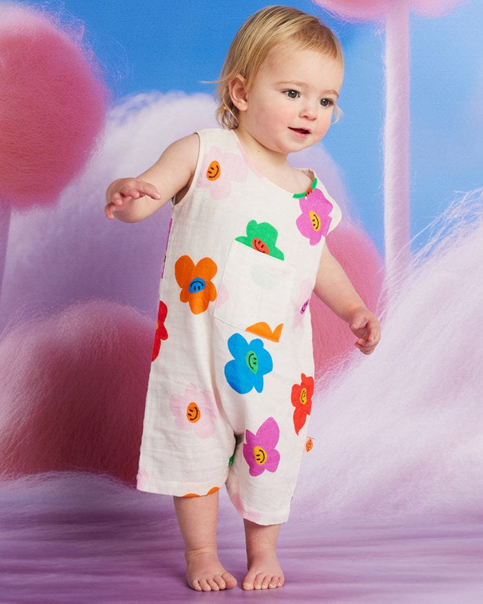 Child wearing a colorful floral dress against a soft, multicolored background