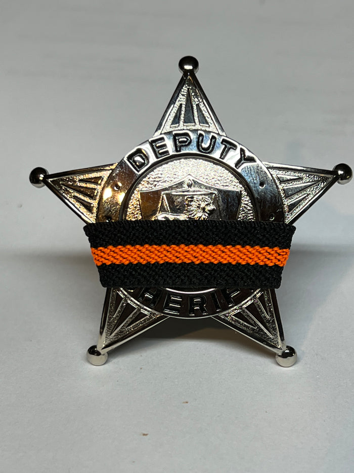 The Stop Gun Violence Wear Orange Awareness / Thin Orange Line Mourning Bands with a thin orange line mourning band 1/2". Band reverses to an all-black mourning band. Public safety officers are wearing thin orange line badge shrouds to raise awareness of gun violence in the community and among police officers, firefighters, Emergency Medical Services and others. Join us in the champagne to Stop Gun Violence. Badges not included.