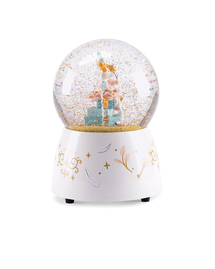 A white music snow globe with a decorated base featuring gold and silver fairy illustrations, containing a miniature fairy figurine and glittery snow inside a clear sphere.