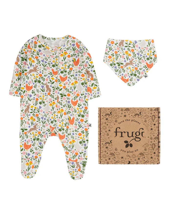 Baby onesie with floral pattern, matching bib, and Frugi packaging on a white background