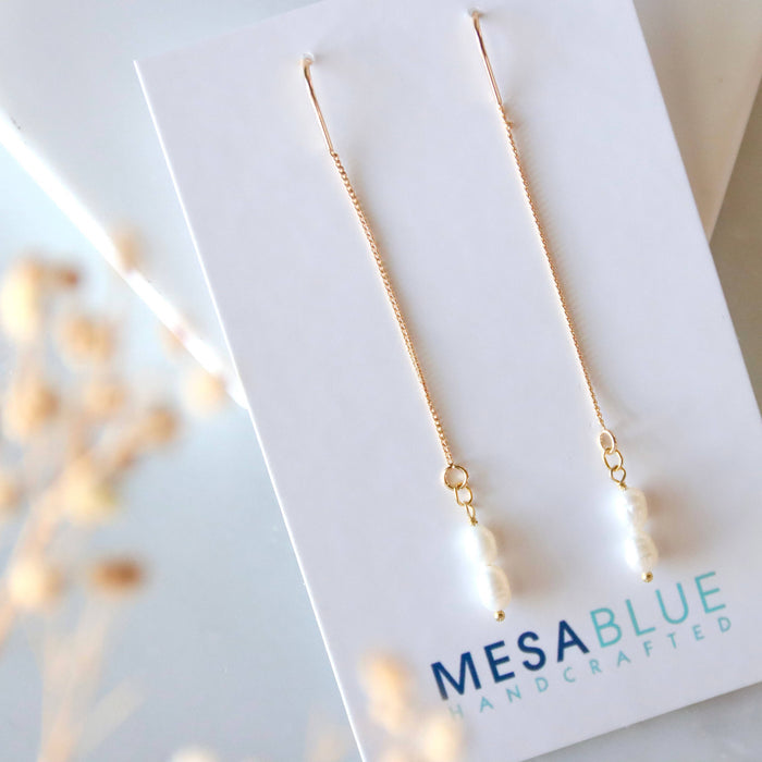 Gold necklace on a Mesa Blue branded card with a blurred background
