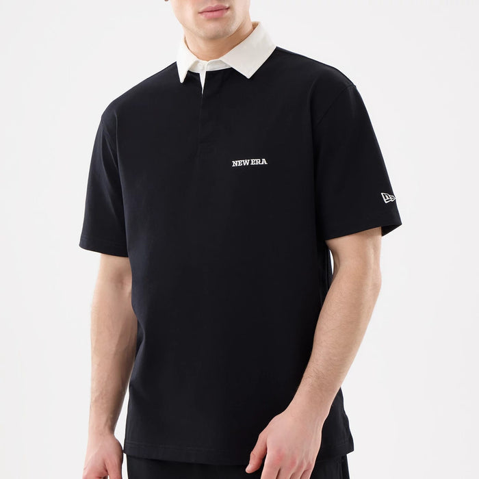 The model is wearing this New Era Short Sleeve Rugby Shirt in black. 3
