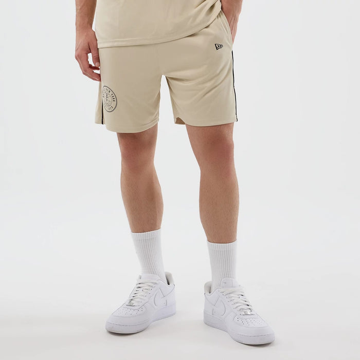The model is wearing these New Era Football Shorts in light beige. 7