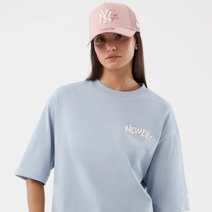 The model is wearing this New Era Fun Block Party Graphic Oversized T-Shirt in pastel blue. 6