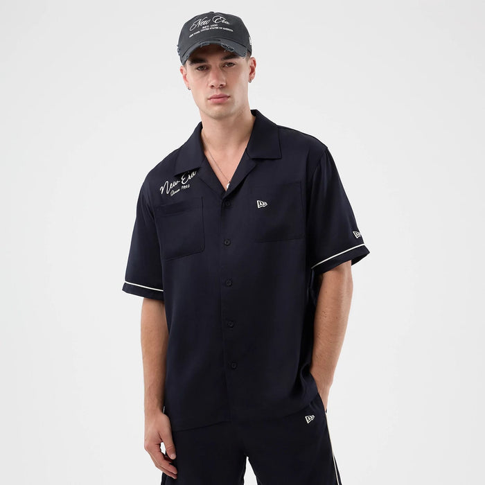 The model is wearing this New Era Graphic Revere Short Sleeve Shirt in navy. 3