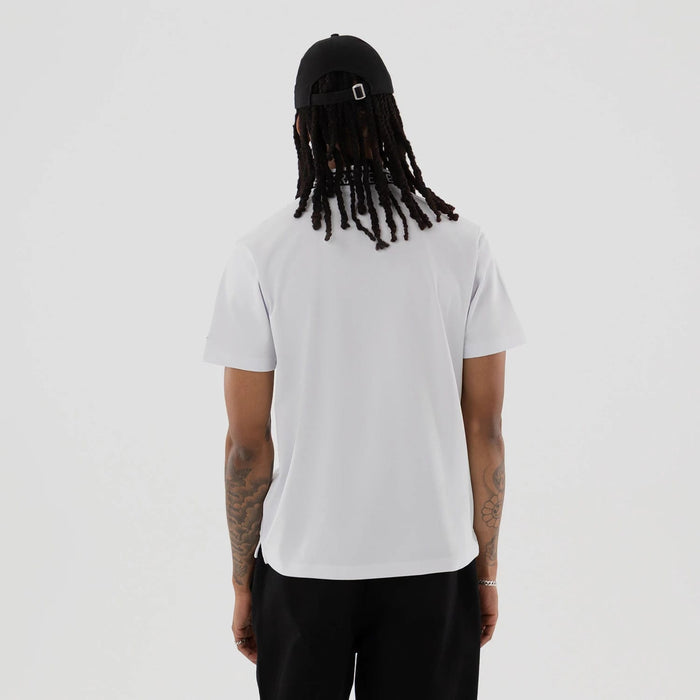 The model is wearing this New Era Kanoko Polo T-Shirt in white. 2