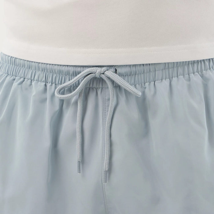 The model is wearing this New Era Swimming Shorts in pastel blue. 7