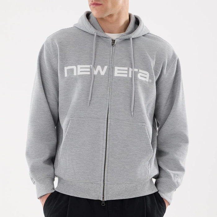 The model is wearing this New Era Waffle Full Zip Hoodie in grey. 3