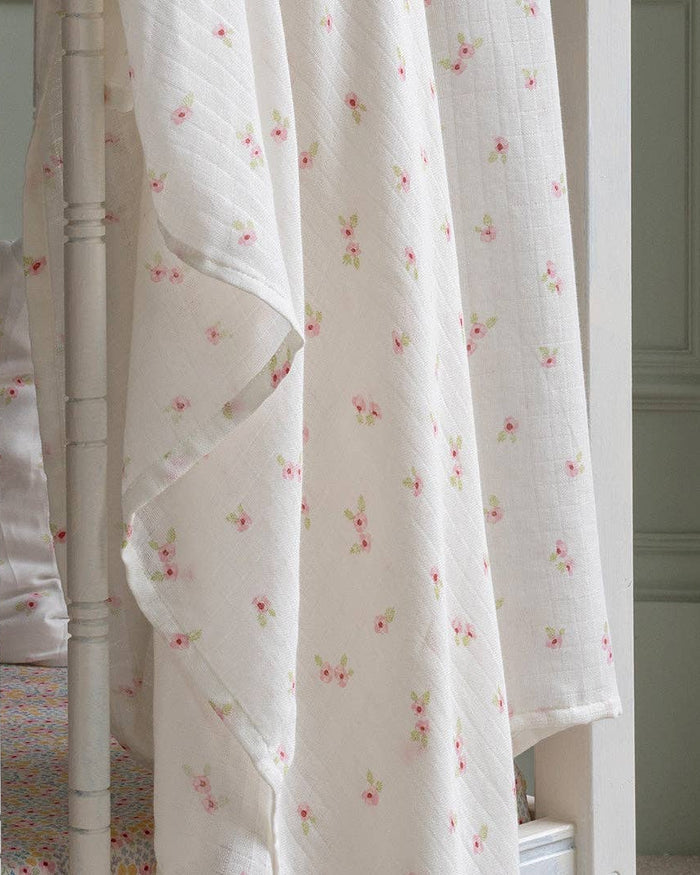 White floral curtain hanging in a room with a neutral color scheme.