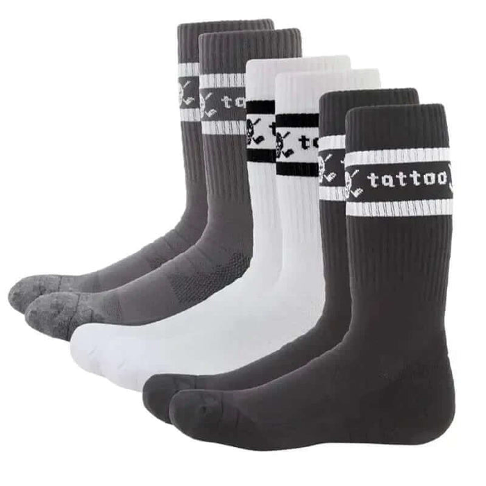 Three pairs of crew-cut golf socks, two in black and one in white, all featuring a skull and crossed clubs logo on the instep and the word 'tattoo' on the back.