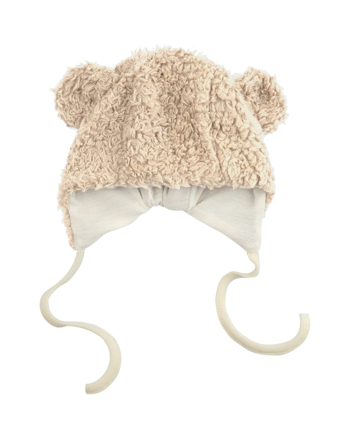 Fluffy beige baby hat with earflaps on a white background