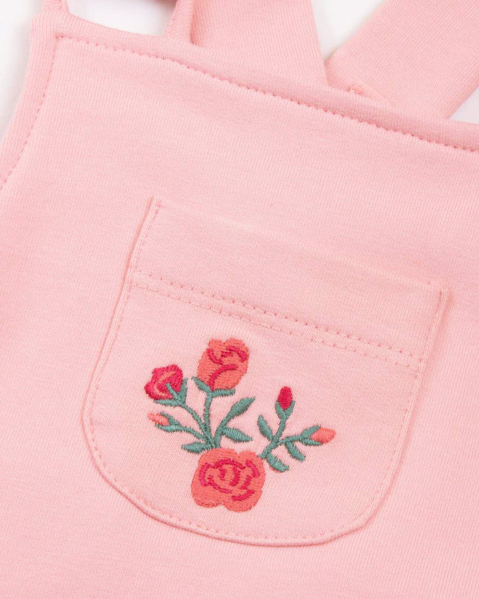 Pink fabric with embroidered floral design on a white background