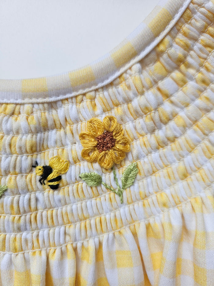 Close-up of a woven basket with embroidered flowers on a white background