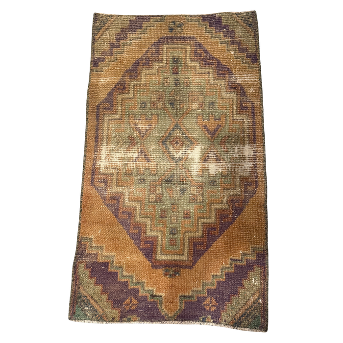 Ochre mini rug with a plum-bordered sage medallion, geometric details, and pronounced pale wear bands across the center.