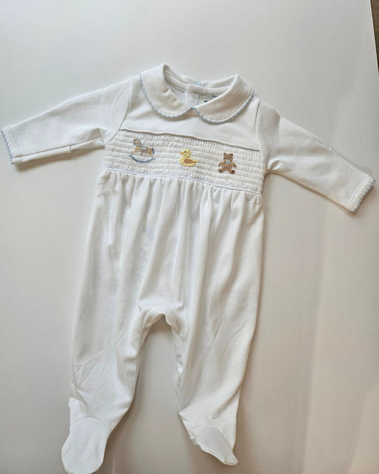 White baby outfit with long-sleeve top and pants on a light gray surface