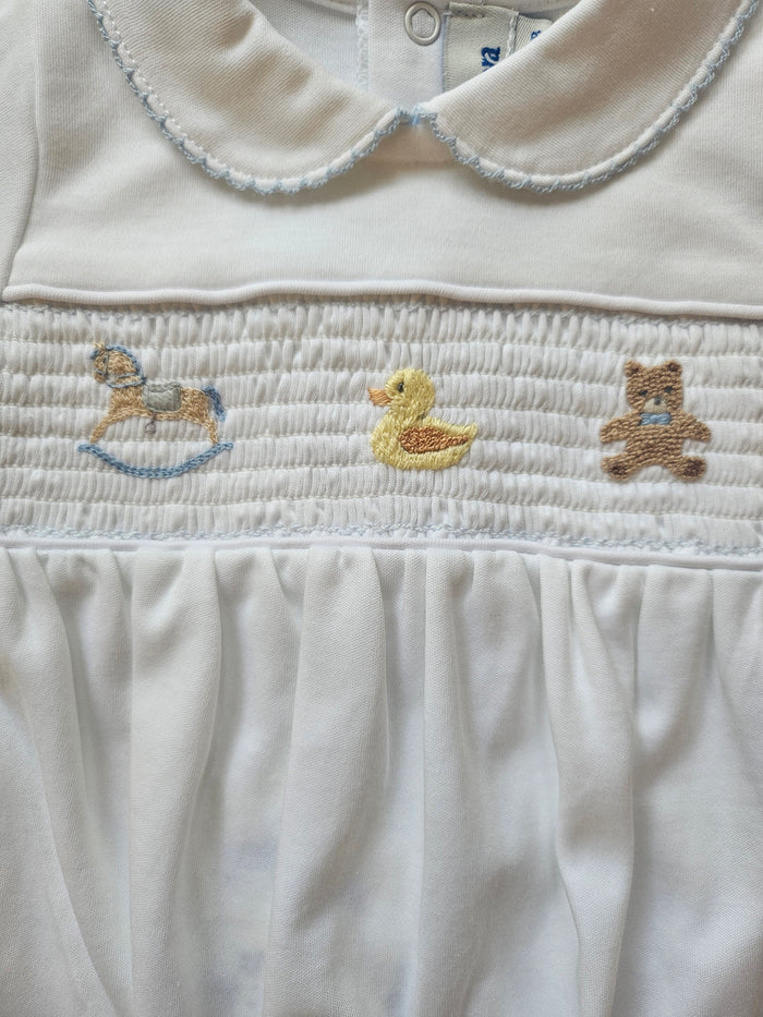 Close-up of a white garment with embroidered stars and a duck design.