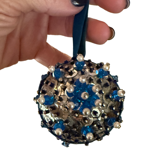 Vintage silver sequin ball ornament with blue and navy beads, pearl-look accents, a floral bead motif, and a blue velvet hanging loop.