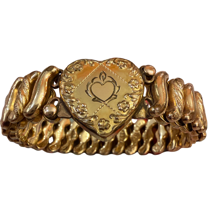 A vintage gold heart-shaped bracelet with a central engraved heart medallion and textured, wavy side bands, shown on a plain white background.