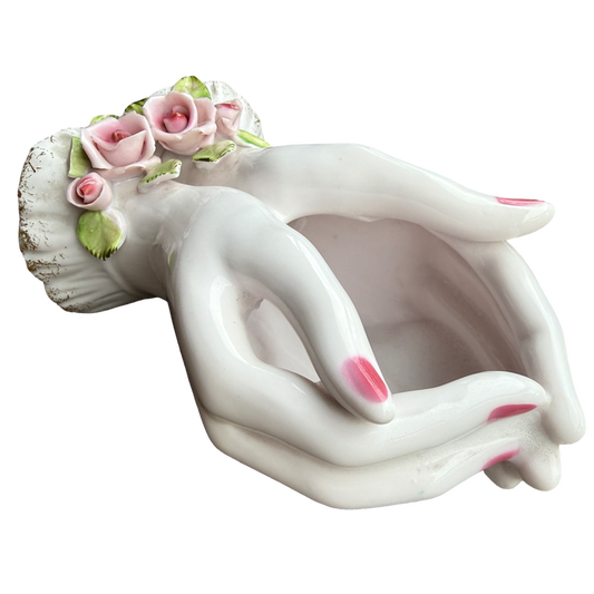 Decorative ceramic planter shaped like a woman's torso with floral hair on a white background