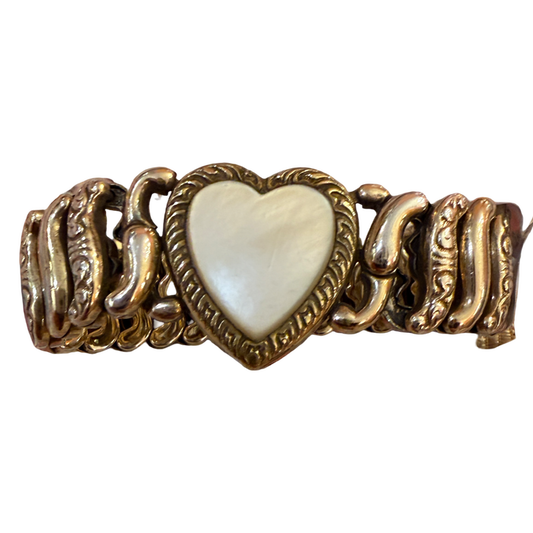 A vintage-style gold-tone chain bracelet featuring a central heart-shaped inlay with a pearlescent white mother-of-pearl finish, set against a plain white background.