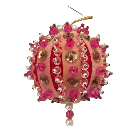 Round vintage peach velvet ornament embellished with rows of pink sequins, pearl-look beads, gold-tone details, and a small bead drop.