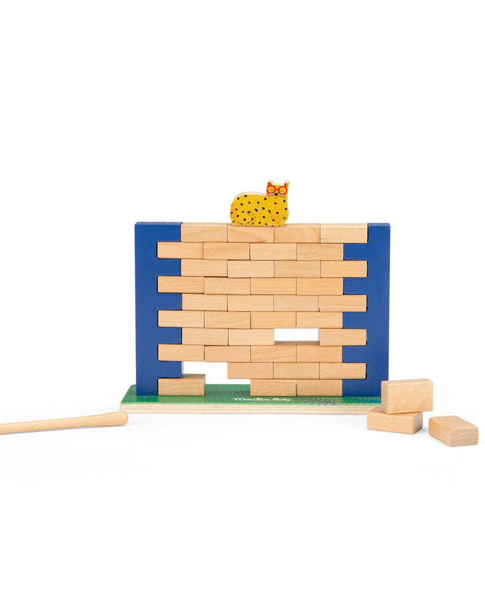 Wooden block tower with a cat figurine on top, accompanied by wooden blocks on a white background