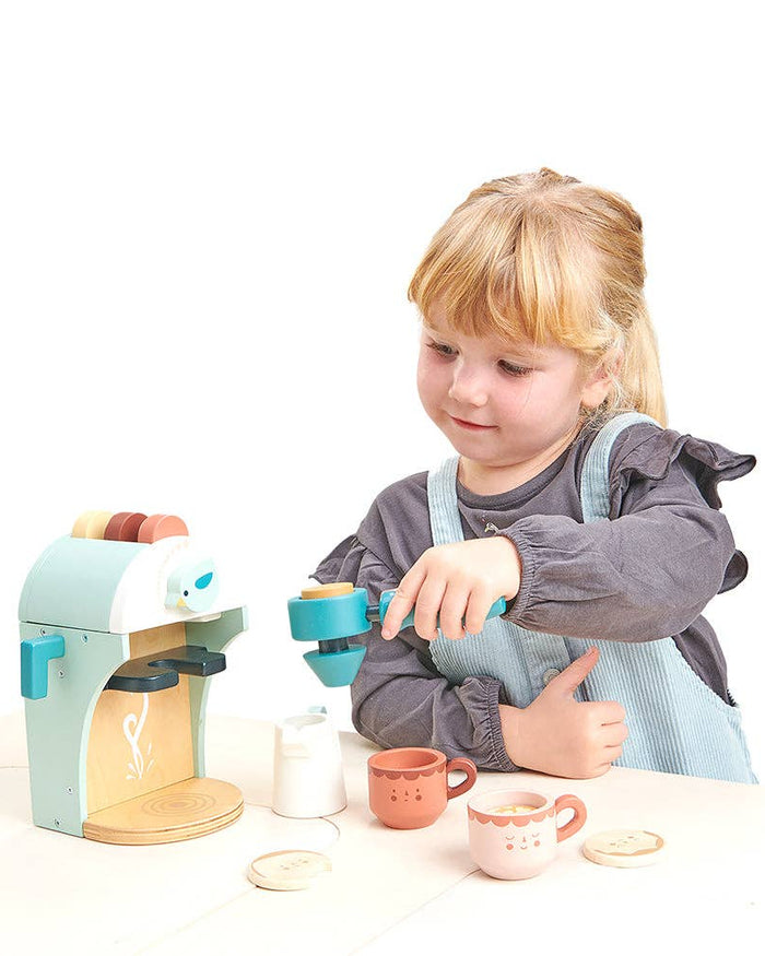 Child playing with a toy tea set on a white background