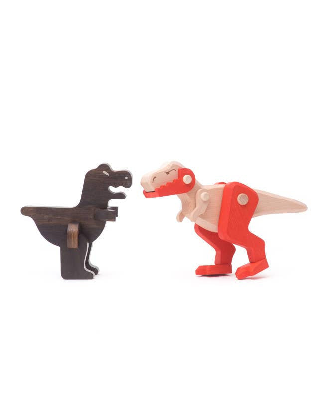 Two toy dinosaurs, one black and one red, facing each other on a white background.